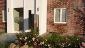 A brick building with a white door and a window. - Deck 4 Modern Retreat (Timmendorfer Strand)