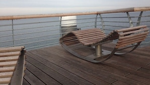 A wooden deck with a metal railing overlooking a body of water. - Deck 4 Modern Retreat (Timmendorfer Strand)