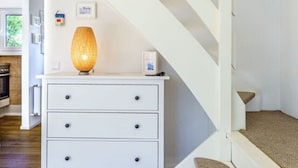A staircase with white railings and a white dresser with drawers. - Holiday Home Heimathafen Am Ringwall (Cuxhaven)