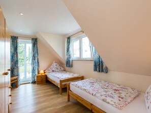 A bedroom with two single beds, a wooden dresser, a desk, and a window with curtains. - Oak Modern Retreat in Uberlingen (Ueberlingen)