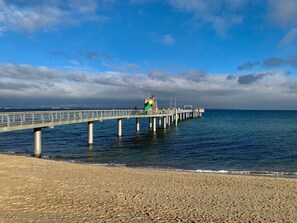 A pier extending into calm waters with a clear sky above. - Holiday Apartment Baltic Sea Sweetheart (Timmendorfer Strand)