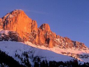 A mountain with a snow-covered peak and rocky cliffs.