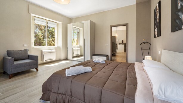 Een moderne slaapkamer met een groot bed, een sofa en een inloopkast.