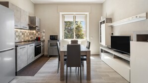 Een moderne keuken met een eethoek, inbouwapparatuur en een groot raam.
