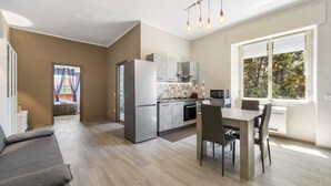 Een moderne keuken met een koelkast, oven en een eethoek.