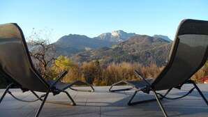 Deux fauteuils confortables placés face à un paysage montagneux.