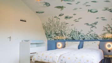 A bedroom with a bed, a nightstand, a wall mural of fish and sea plants, and two pendant lights.