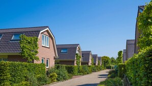 A residential street with houses featuring pitched roofs and brick exteriors. - Holiday Home in Noordwijk Near the Beach (Noordwijk)