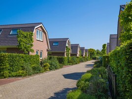 Una calle residencial con casas de techos a dos aguas y fachadas de ladrillo.