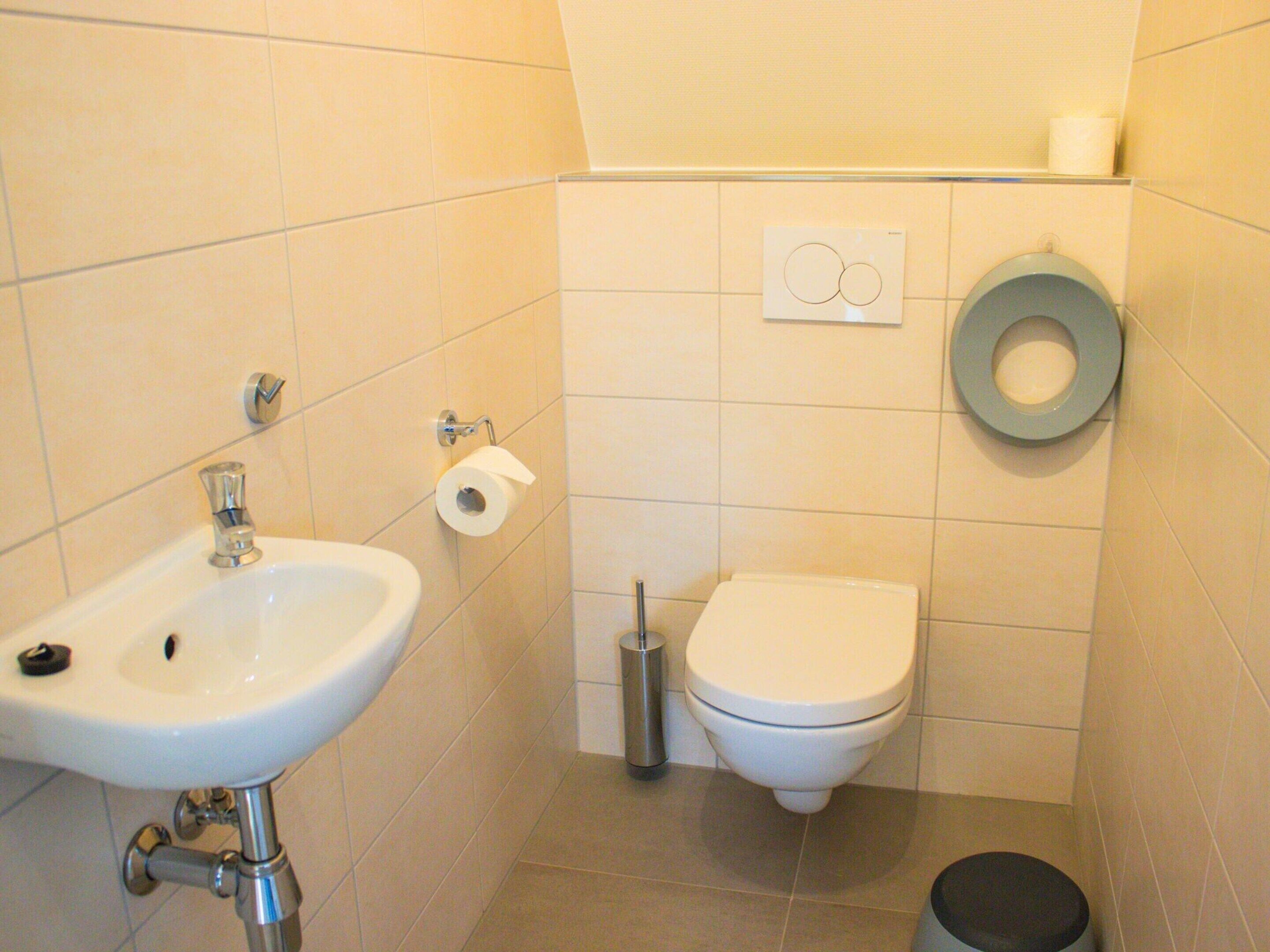 A small bathroom with a sink, toilet, and bidet.
