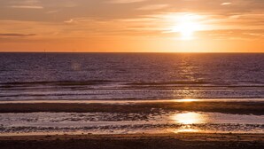 A sunset over the ocean with a clear sky. - Holiday Home in Noordwijk Near the Beach (Noordwijk)
