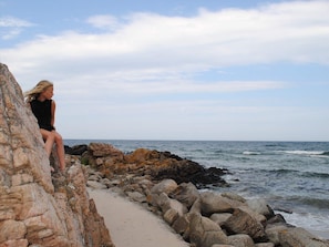 A person sitting on a rocky ledge overlooking the ocean. - Luxury Seaside Retreat - By Traum Ferienwohnungen (Allinge)