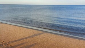 Una playa con cielo despejado y mar tranquilo.