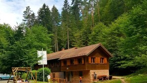 A wooden cabin with a sloped roof, surrounded by dense forest. - Holiday Home Kobel Comfortable Vacation Home (Elmstein)