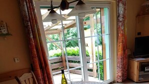 A dining area with a round table, chairs, a bottle of wine, and a glass. - Holiday Home Kobel Comfortable Vacation Home (Elmstein)