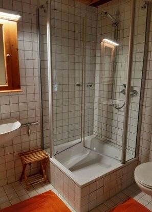 A modern bathroom with a glass-enclosed shower, a wooden stool, and a white sink. - Lovely Apartment in Kobern-gondorf (Kobern-Gondorf)