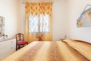A bedroom with a bed, a chair, a dresser, and a painting on the wall. - 3890 Villetta Soliento by Barbarhouse (Porto Cesareo)