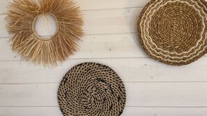 Trois paniers tressés de différentes tailles et de différents modèles, posés sur une surface en bois blanc.