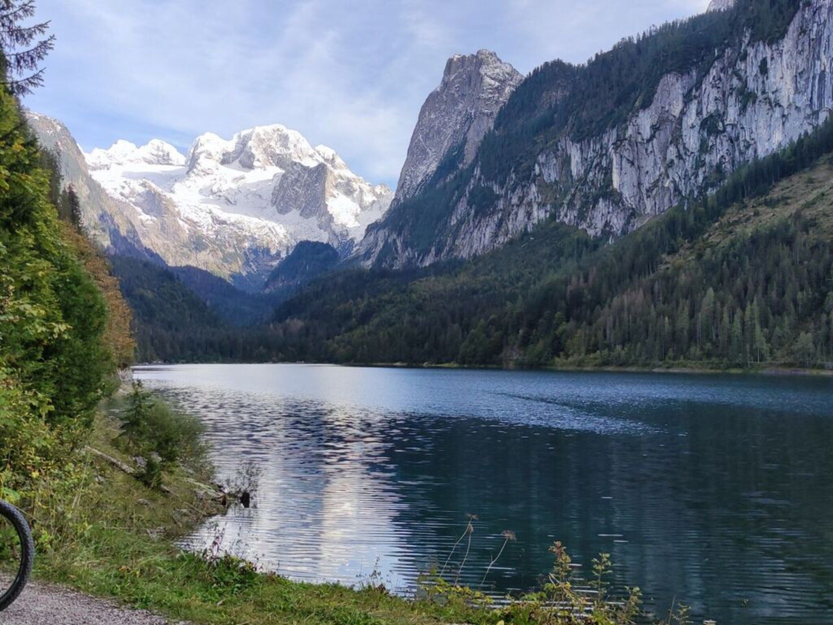 Un lago rodeado de montañas y un bosque denso.