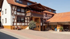Un edificio tradicional con entramado de madera, un balcón y sillas en la terraza.