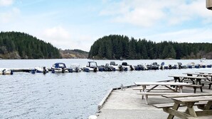 A dock with picnic tables and boats moored in the background. - 8 Person Holiday Home in Seim (Alver)