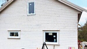 A two-story house with a gabled roof, two windows on the ground floor, and a small window on the upper floor. - 8 Person Holiday Home in Seim (Alver)