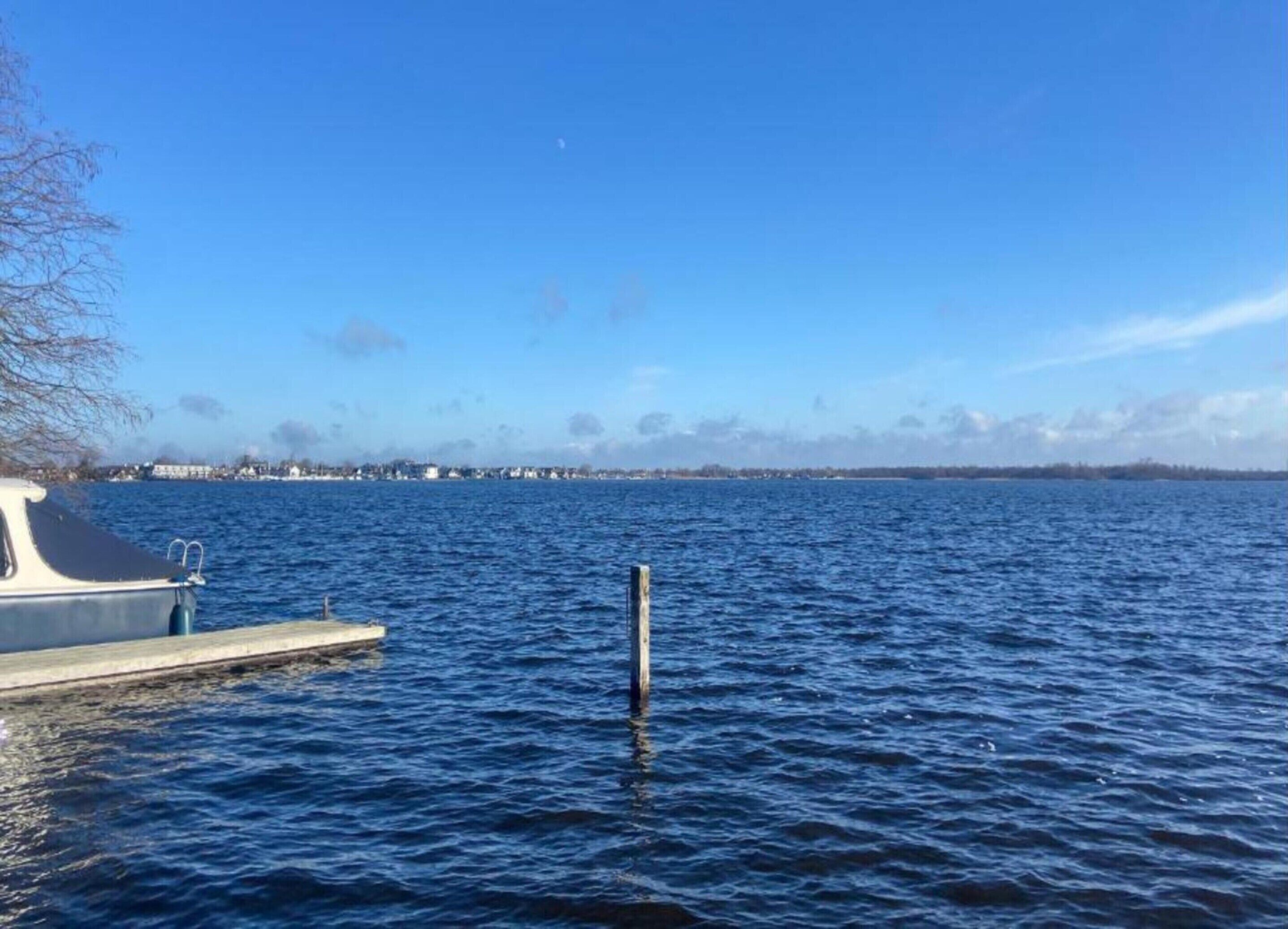 A calm lake with a dock and a boat.