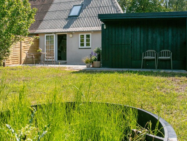 A house with a sloped roof, a front door, and a small porch with chairs.