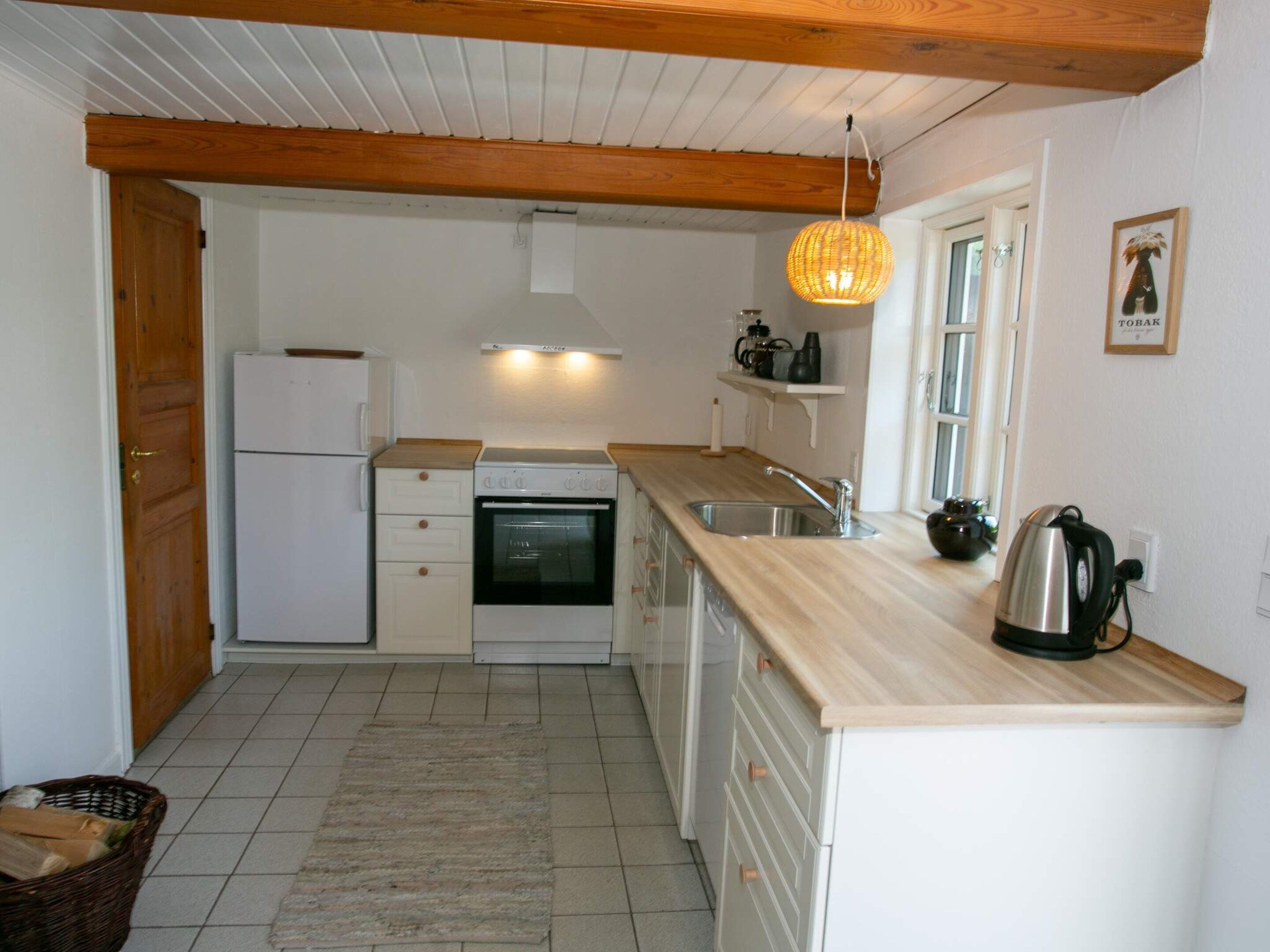 A compact kitchen with a refrigerator, oven, and sink.