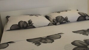 A bed with floral patterned bedding and a white headboard. - Apartment Sunrise (Dugi Rat)