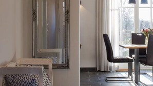 A modern room with a large mirror, a dining table with chairs, and a patterned sofa. - House Summerlove Comfortable Vacation Home (Ostseebad Prerow)