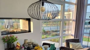 Un comedor con una mesa de madera, sillas y una lámpara colgante.