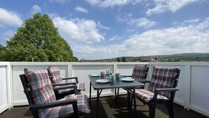 A rooftop terrace with four black chairs and a table, featuring plaid cushions. - Haus Mariechen Comfortable Holiday Residence (Frielendorf)