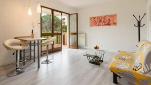 A modern living room with a dining area, a sofa, and a table with chairs. - Residenza Montecatini (Montecatini Terme)