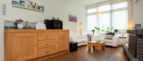 Ein Wohnzimmer mit Holzschrank, weißem Sofa und Kamin.