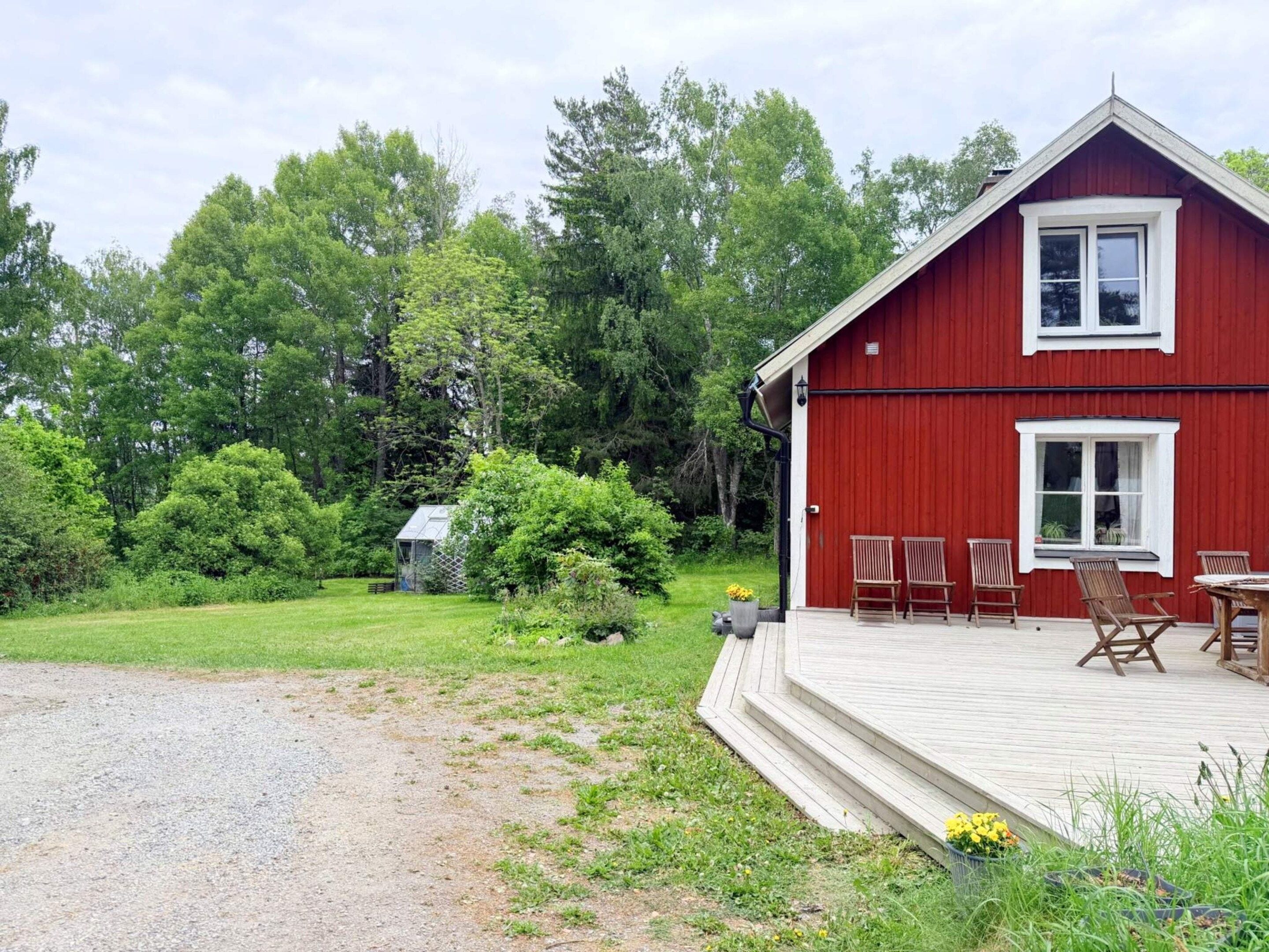 A red building with a porch and outdoor seating.