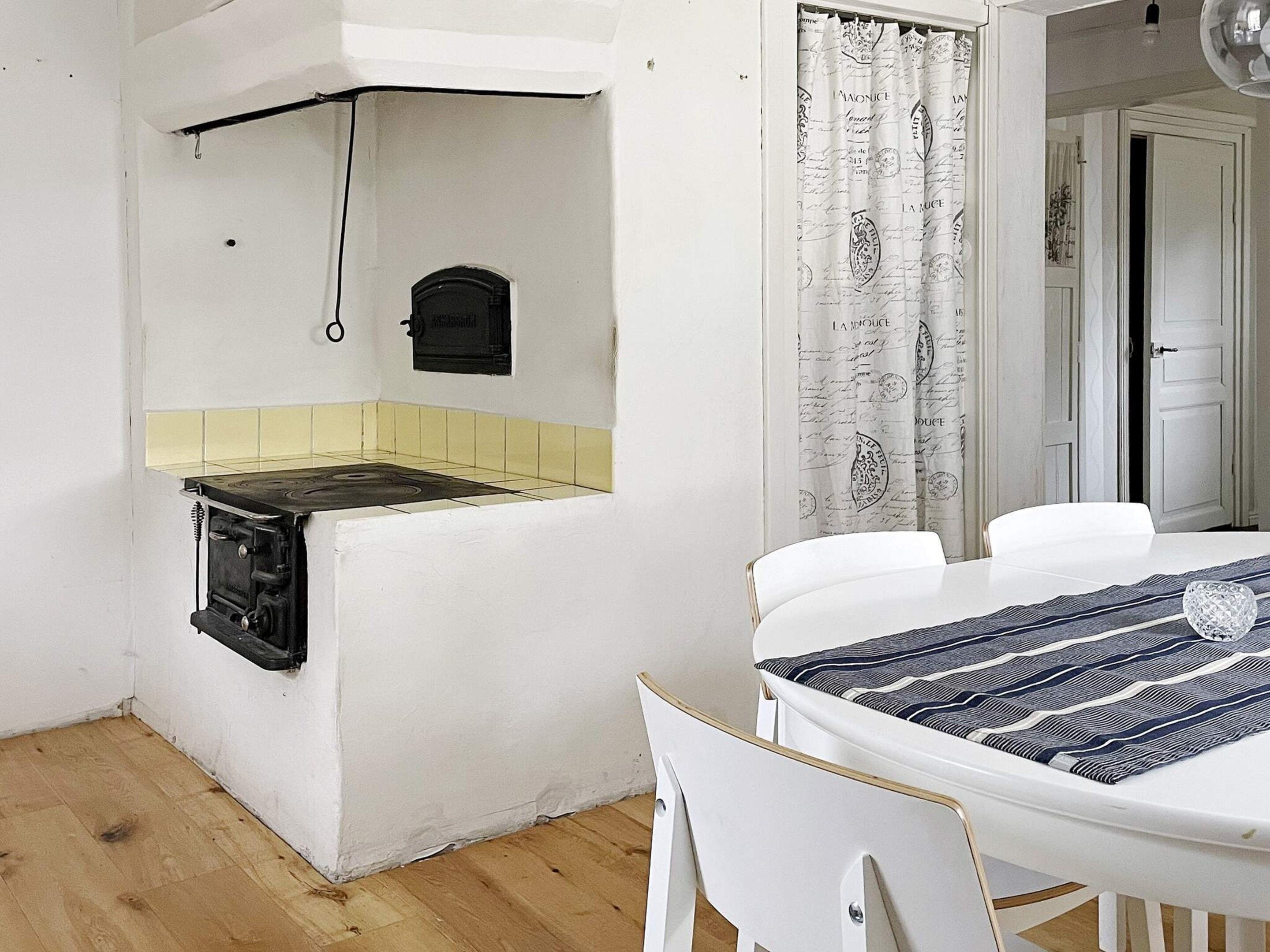 A compact kitchen with a stove, a small oven, and a yellow-tiled backsplash.