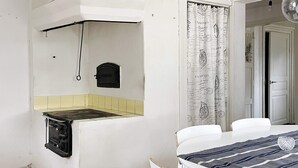 A compact kitchen with a stove, a small oven, and a yellow-tiled backsplash. - 4 Star Holiday Home in Bro (Bro)
