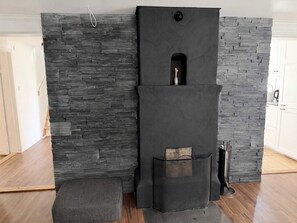 A room with a stone wall, a black cabinet with a small window, and a wooden bench. - 4 Star Holiday Home in Bro (Bro)