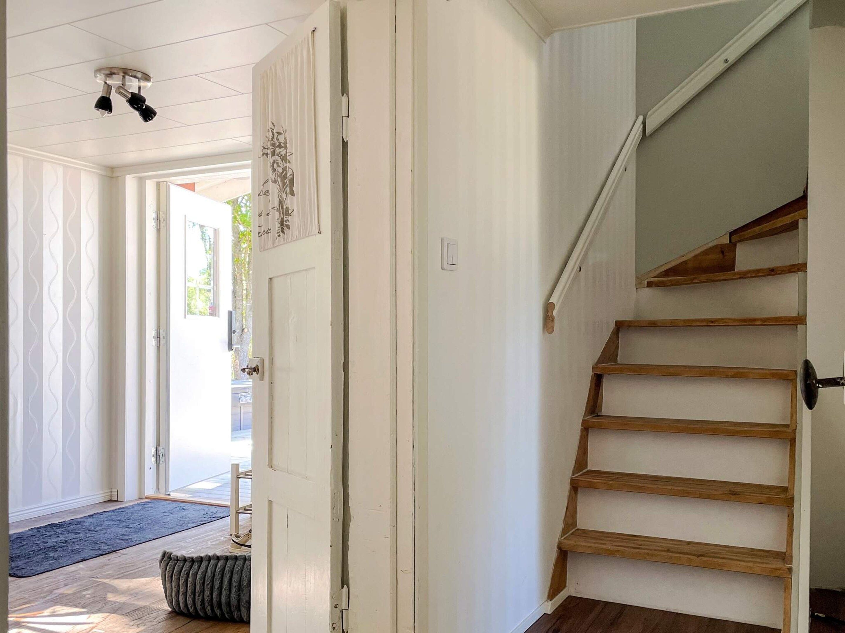 A staircase with wooden steps and a white wall.