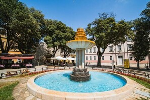 A fountain with a tiered design, surrounded by a stone border and a circular pool. - Adalene Comfortable Holiday Residence (Liznjan)