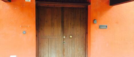 A wooden double door with a number '22' above it, a 'RECEPTION' sign, and a 'LETTERE' sign on the wall.