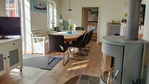 Moderni keittiö, jossa on ruokailutila, suuri liesi ja televisio.