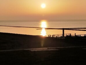 A sunset over a calm body of water with a pier extending into the water. - Holiday Home Rike Comfortable Vacation Home (Emmelsbuell-Horsbuell)
