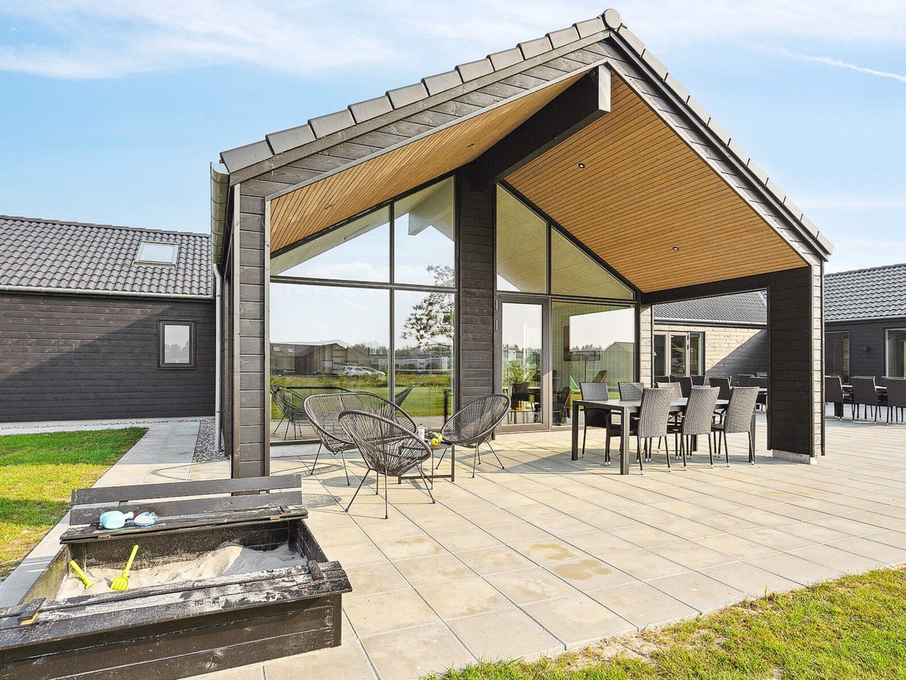 A modern outdoor patio with a wooden pergola, seating area, and a fire pit.