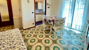 Une pièce comprenant un lit, une table à manger avec des chaises, un coin cuisine et une salle de bain.