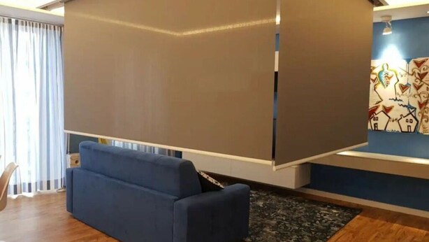 Un salon moderne avec un canapé bleu, un plancher en bois et un grand écran coulissant.