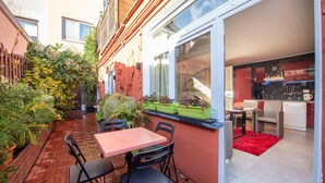 Un patio con una mesa y sillas, un sendero de ladrillo y vistas a una cocina moderna.