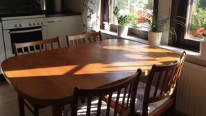 A kitchen with a dining table and chairs, a stove, and a view of a lake through large windows. - 4 Star Holiday Home in Bonassund-by Traum (Bonässund)