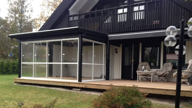 A modern house with a glass-enclosed porch and outdoor seating area. - 4 Star Holiday Home in Bonassund-by Traum (Bonässund)